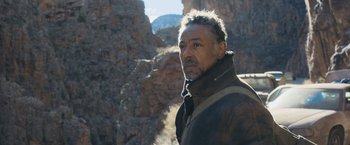 Movie still from “Maze Runner: The Scorch Trials” (2015), directed by Wes Ball – A person wearing a jacket near a mountain; Close Up shot, Low angle