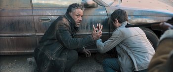 Movie still from “Maze Runner: The Scorch Trials” (2015), directed by Wes Ball – A man and a boy in front of an old car; Medium shot, High angle
