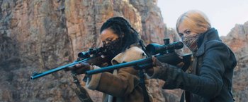 Movie still from “Maze Runner: The Scorch Trials” (2015), directed by Wes Ball – A person holding a rifle in their hands; Medium shot, Over the shoulder angle