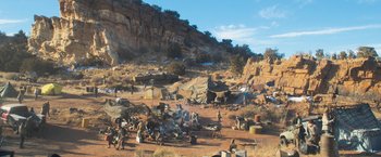 Movie still from “Maze Runner: The Scorch Trials” (2015), directed by Wes Ball – A group of people standing around a dirt field; Extreme Wide shot, High angle