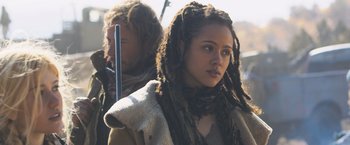 Movie still from “Maze Runner: The Scorch Trials” (2015), directed by Wes Ball – A woman with dreads holding a stick in front of a man; Close Up shot, Over the shoulder angle