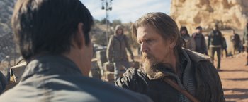 Movie still from “Maze Runner: The Scorch Trials” (2015), directed by Wes Ball – A man with long hair and a beard talking to another man; Medium shot, Over the shoulder angle