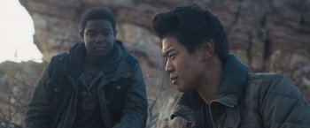 Movie still from “Maze Runner: The Scorch Trials” (2015), directed by Wes Ball – Two young men sitting next to each other on rocks; Close Up shot, Over the shoulder angle