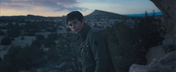 Movie still from “Maze Runner: The Scorch Trials” (2015), directed by Wes Ball – A young man standing in front of a mountain range; Medium shot, Low angle