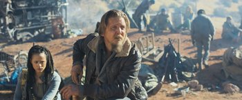 Movie still from “Maze Runner: The Scorch Trials” (2015), directed by Wes Ball – A man sitting on a chair in the desert; Medium shot, Over the shoulder angle