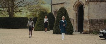 Movie still from “Me Before You” (2016), directed by Thea Sharrock – A group of people walking in front of a building; Wide shot, Over the shoulder angle