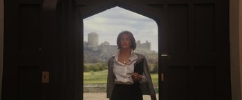 Movie still from “Me Before You” (2016), directed by Thea Sharrock – A woman standing in front of a castle holding a book; Medium shot, Low angle
