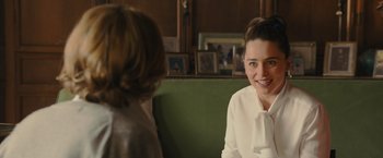 Movie still from “Me Before You” (2016), directed by Thea Sharrock – A woman sitting next to another woman on a green couch; Close Up shot, Over the shoulder angle