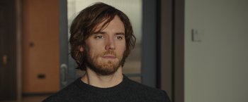 Movie still from “Me Before You” (2016), directed by Thea Sharrock – A person with long hair and a beard; Close Up shot, Over the shoulder angle