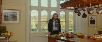 Movie still from “Me Before You” (2016), directed by Thea Sharrock – A woman standing in a kitchen preparing food; Medium shot, Low angle