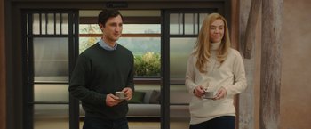 Movie still from “Me Before You” (2016), directed by Thea Sharrock – A man and a woman standing next to each other holding cell phones; Medium shot, Over the shoulder angle