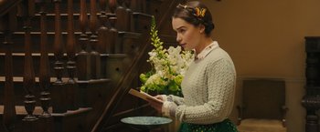 Movie still from “Me Before You” (2016), directed by Thea Sharrock – A young woman holding a book in her hands; Medium shot, Over the shoulder angle