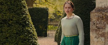 Movie still from “Me Before You” (2016), directed by Thea Sharrock – A woman in a green skirt standing in front of bushes; Medium shot, Over the shoulder angle