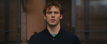 Movie still from “Me Before You” (2016), directed by Thea Sharrock – A young man with a beard is looking at the camera; Close Up shot, Over the shoulder angle