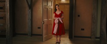 Movie still from “Me Before You” (2016), directed by Thea Sharrock – A woman in a red dress is holding a pink scarf; Medium shot, Over the shoulder angle