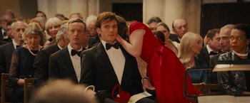 Movie still from “Me Before You” (2016), directed by Thea Sharrock – A man in a tuxedo and a woman in a red dress; Close Up shot, Over the shoulder angle