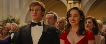 Movie still from “Me Before You” (2016), directed by Thea Sharrock – A group of people standing next to each other in formal wear; Close Up shot, Over the shoulder angle