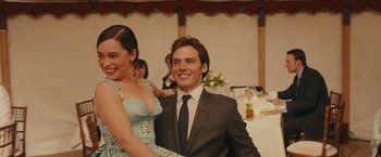 Movie still from “Me Before You” (2016), directed by Thea Sharrock – A man and a woman posing for a picture; Medium shot, Low angle