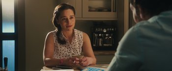 Movie still from “Me Before You” (2016), directed by Thea Sharrock – A woman sitting at a table with a cell phone in her hand; Close Up shot, Over the shoulder angle