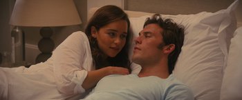 Movie still from “Me Before You” (2016), directed by Thea Sharrock – A young woman sitting next to a man in a bed; Close Up shot, Over the shoulder angle
