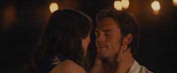 Movie still from “Me Before You” (2016), directed by Thea Sharrock – A man and a woman face to face in front of lights; Close Up shot, Over the shoulder angle