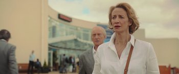 Movie still from “Me Before You” (2016), directed by Thea Sharrock – A woman and a man are walking in front of a building; Close Up shot, Low angle
