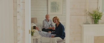 Movie still from “Me Before You” (2016), directed by Thea Sharrock – A man and a woman sitting next to each other in a room; Wide shot, High angle