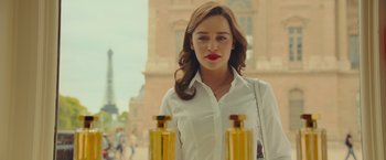 Movie still from “Me Before You” (2016), directed by Thea Sharrock – A woman in a white shirt is holding two bottles; Close Up shot, Over the shoulder angle