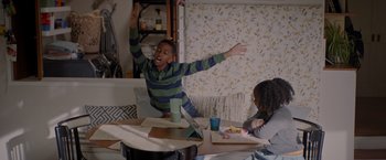 Movie still from “Me Time” (2022), directed by John Hamburg – Two children sitting at a table with a plate of food in front of them; Medium shot, Over the shoulder angle