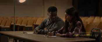 Movie still from “Me Time” (2022), directed by John Hamburg – A man and a woman sitting at a wooden table; Medium shot, Over the shoulder angle