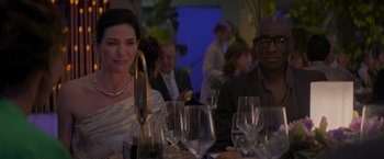 Movie still from “Me Time” (2022), directed by John Hamburg – A group of people sitting at a table with wine glasses on it; Medium shot, Over the shoulder angle