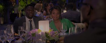 Movie still from “Me Time” (2022), directed by John Hamburg – A woman sitting at a table with a glass of wine in front of her; Medium shot, Over the shoulder angle