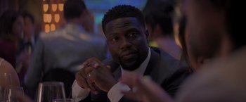 Movie still from “Me Time” (2022), directed by John Hamburg – A person wearing a suit and tie; Close Up shot, Over the shoulder angle