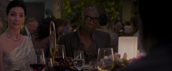 Movie still from “Me Time” (2022), directed by John Hamburg – A man sitting at a table with a glass of white wine; Close Up shot, Over the shoulder angle