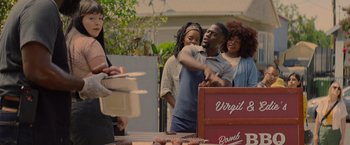 Movie still from “Me Time” (2022), directed by John Hamburg – A group of people standing next to each other near a table; Medium shot, Over the shoulder angle