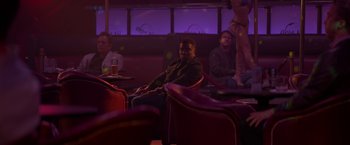 Movie still from “Me Time” (2022), directed by John Hamburg – A group of people sitting in a room at night; Wide shot, Over the shoulder angle