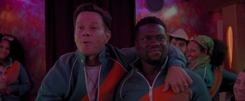 Movie still from “Me Time” (2022), directed by John Hamburg – A couple of men sitting next to each other; Medium shot, Over the shoulder angle