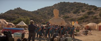 Movie still from “Me Time” (2022), directed by John Hamburg – A group of people standing in front of a statue of a man; Extreme Wide shot, Low angle