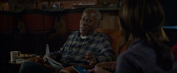 Movie still from “Me Time” (2022), directed by John Hamburg – An older man sitting in a chair talking to a woman; Close Up shot, Over the shoulder angle