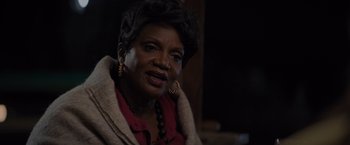 Movie still from “Me Time” (2022), directed by John Hamburg – An older black woman wearing a red shirt and a red jacket; Close Up shot, Over the shoulder angle