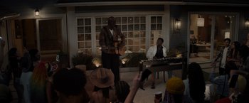 Movie still from “Me Time” (2022), directed by John Hamburg – A man playing a guitar while a man plays a keyboard; Wide shot, Over the shoulder angle