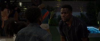 Movie still from “Me Time” (2022), directed by John Hamburg – Two men standing next to each other on a field; Medium shot, Over the shoulder angle