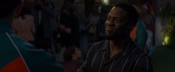 Movie still from “Me Time” (2022), directed by John Hamburg – A man in striped shirt looking to his left; Close Up shot, Over the shoulder angle