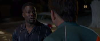 Movie still from “Me Time” (2022), directed by John Hamburg – A man in a striped shirt talking to another man in a green shirt; Close Up shot, Over the shoulder angle