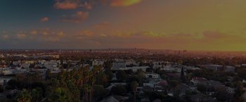 Movie still from “Me Time” (2022), directed by John Hamburg – A view of a city at sunset from a hill; Extreme Wide shot, High angle