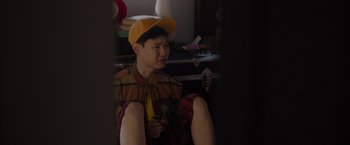 Movie still from “Me Time” (2022), directed by John Hamburg – A man in a yellow hat is sitting down; Medium shot, High angle