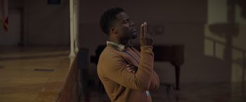 Movie still from “Me Time” (2022), directed by John Hamburg – A man in a brown sweater is praying; Close Up shot, Over the shoulder angle