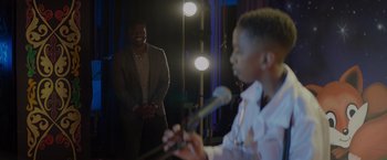 Movie still from “Me Time” (2022), directed by John Hamburg – A man standing in front of a microphone and another man standing in front of a microphone; Medium shot, Over the shoulder angle