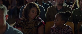 Movie still from “Me Time” (2022), directed by John Hamburg – A woman sitting next to a child in a crowd; Close Up shot, Over the shoulder angle