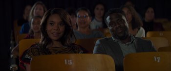 Movie still from “Me Time” (2022), directed by John Hamburg – A group of people sitting in a row of seats; Close Up shot, Over the shoulder angle
